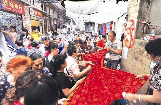 图为:破布街今日开始拆除。昨日商户大甩卖吸引了众多市民抢购