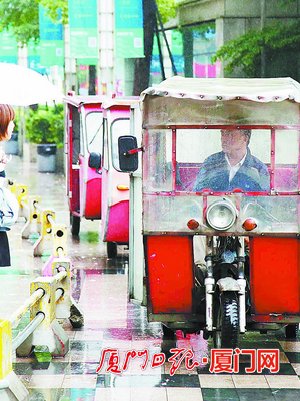 梧村汽车站的三轮黑摩的排队候客。（本报记者 王火炎 摄）