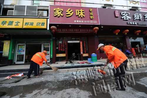 环卫工人清理爆炸后的玻璃碎片