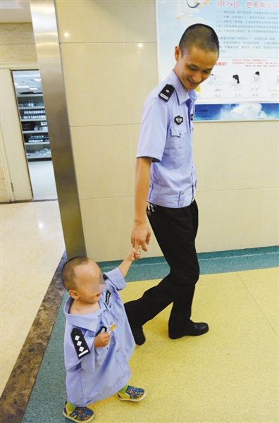 昨日，民警牽著多多(化名)在派出所里玩耍。重慶晨報記者胡杰攝