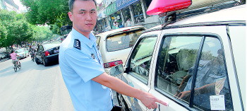 陈光副所长指着被砍的警车向记者介绍案情,当时醉酒男子抡刀砍妻子。记者李培乐摄