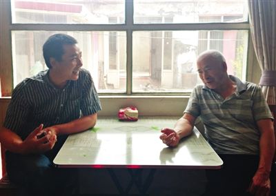 昨日午饭后,李万良和王瑞全父子坐在客厅唠嗑。新京报记者 李相蓉 摄