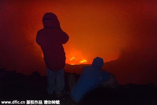 他不顾生命危险，决定走到火山口边上一探究竟，拍下了这组火山口里岩浆翻滚的壮观景象。