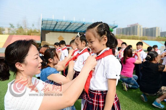 在盛福实验小学,家长正为自己的孩子系上红领巾