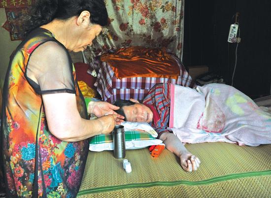 張昊照顧病床上的老伴，沒有時間再精心照料收養(yǎng)的腦癱孩子。