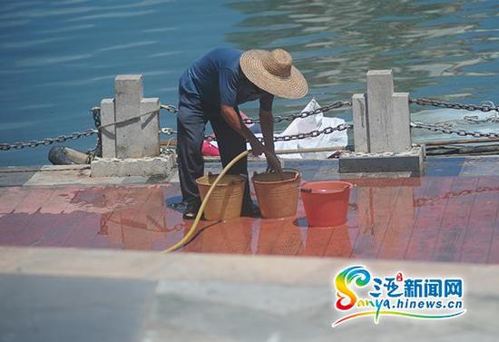 6月4日,三亚市民在路边接水。(三亚新闻网记者沙晓峰摄)