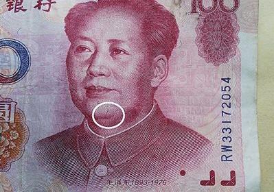 99年版百元大钞头像右边痣下方,有一条3毫米的红色竖曲线(白圈处)。