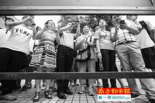 昨日下午,广州市第二十一中学,考场门口张贴着考场座位安排等信息,考生与家长前来踩点,用手机拍下座位位置。南都记者 林宏贤 摄
