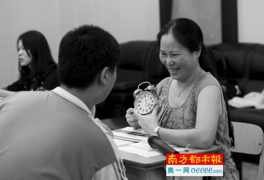 6月6日,广州市旅游商务职业学校,面试专家拿着闹钟问考生问题。南都记者 冯宙锋 摄