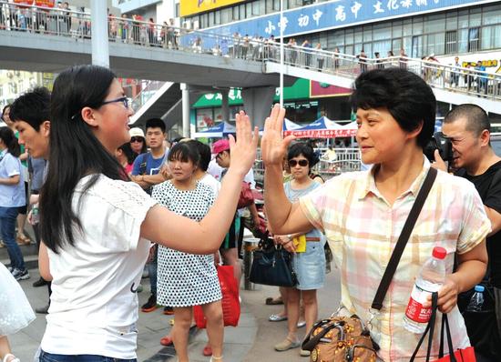 即將進(jìn)入考場(chǎng)，一名考生與家長(zhǎng)擊掌鼓勁。