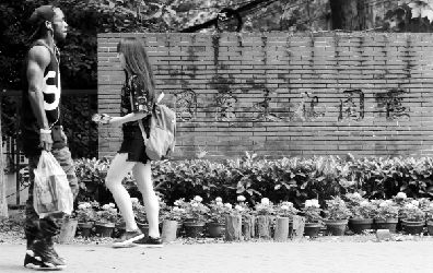 武汉一高校中外联合办学园区,留学生从园区前走过