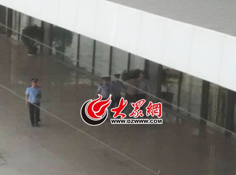 办案民警押着犯罪嫌疑人赵某国从菏泽火车站站台上走过，准备乘车前往南昌