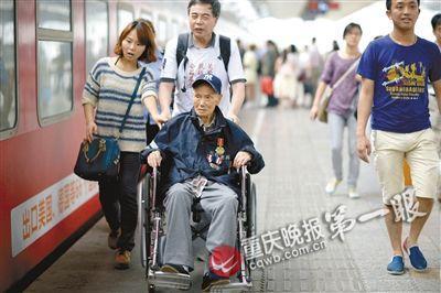 102岁抗战老兵曹廷明坐轮椅,在志愿者的搀扶下踏上回家之路。