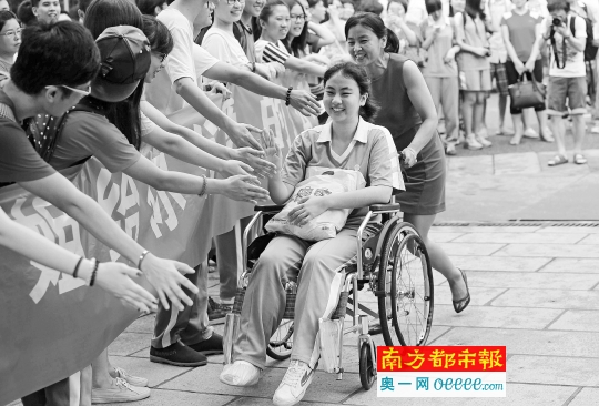昨日,广州执信中学考场,一位妈妈推着轮椅上的女儿进入校门,这位女生自信地和前来打气加油的师兄师姐一一击掌。该考生半个月前打篮球扭伤了脚,右脚还打着石膏。妈妈说,为练习自己控制出行,女儿两只手都磨出了茧。 南都记者 冯宙锋 摄