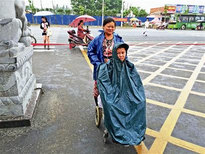 图为:余傲的妈妈推着他步入曾都一中考场。 记