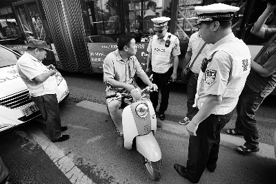 今晨，民警在南三环主路对违反上路的摩托车进行查处  摄/法制晚报记者 杨益
