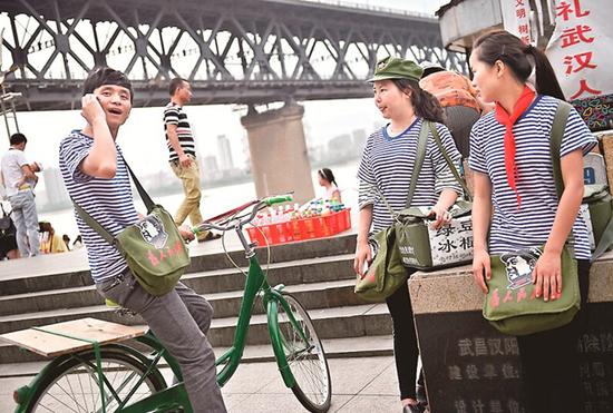 图为:近日,几名大学生在长江大桥下玩“穿越”卖老冰棒