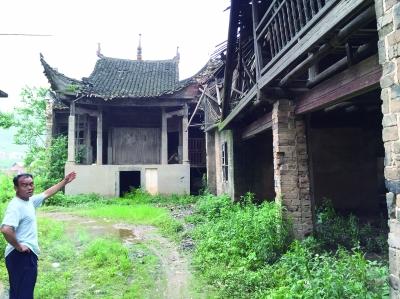 6月4日，董泽春在介绍杨林村的古戏台。2014年编制的修缮方案里，戏台旁的这处房子还没有坍塌。