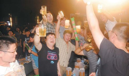 夏日的夜晚，扎啤加烤串，人们尽情狂欢。本报记者左庆摄