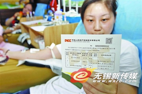 14日,一位无偿献血者阅读保险条款。