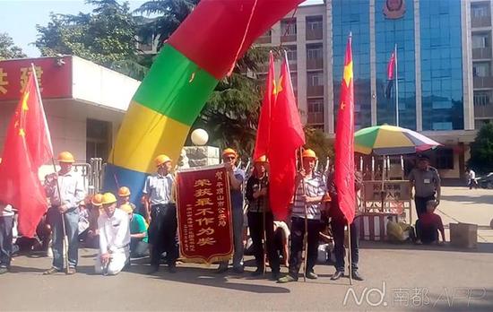 19日上午,张蓬冲在内的数十位工友在到平顶山市公安局门口送“不作为”锦旗。图片由受访者提供。