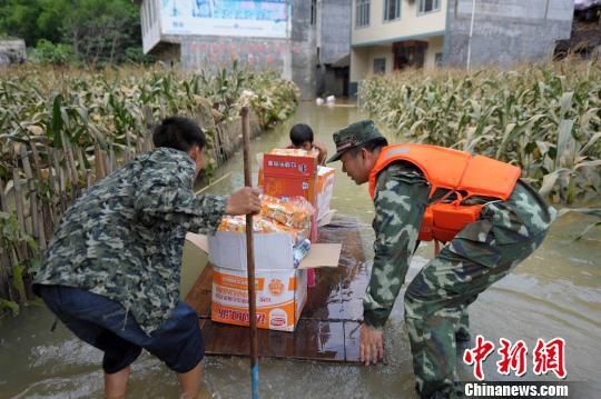 武警官兵帮助村民用简易木筏运送食品和水。　蒋雪林 摄