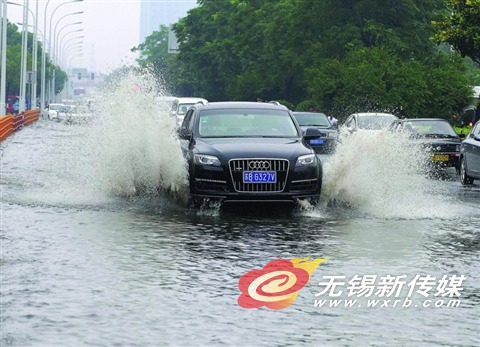 昨天,车辆经过惠山大道积水路面。(还月亮 摄)