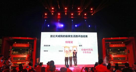 昆仑润滑油相关负责人与特等奖获得者合影,两旁是这次特等奖奖品——价值40万元的卡车车头