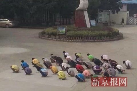 学生被该教师罚蹲在操场上。学生供图。