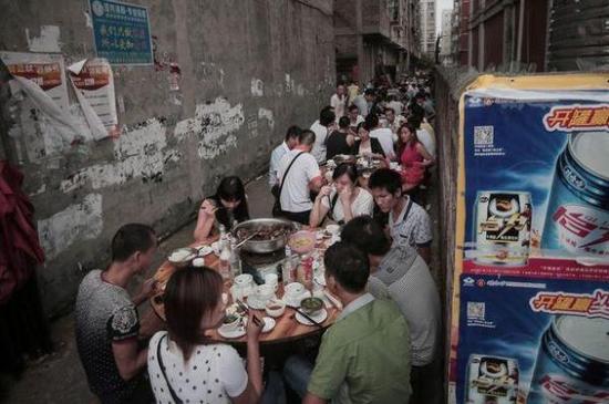 玉林当地人在街上吃狗肉。(图片来源:《镜报》)