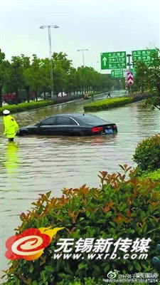 道路积水严重,小轿车已淹道路中央。