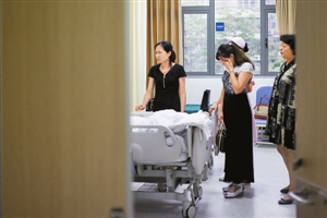 被打护士的小姨见到躺在病床上的侄女不禁掩面哭泣。