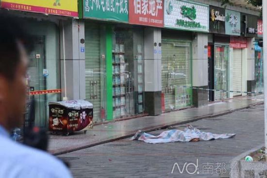 事发现场,当事人尸体已经被遮盖。地面上遍布碎玻璃和血迹
