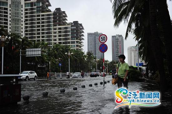 6月23日，行人从三亚榆亚路积水路段通过。(三亚新闻网记者沙晓峰摄)