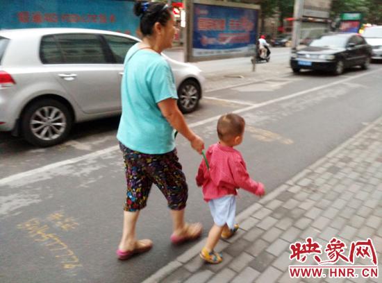 奶奶用绳拴住孙子逛街