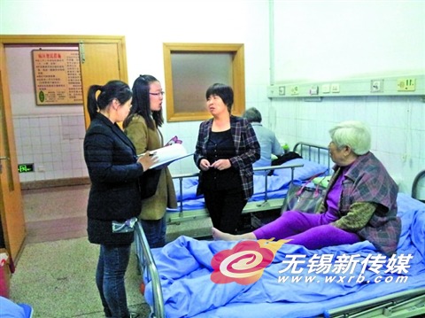 大病保险专管员在向住院病人及家属宣传大病保险政策。