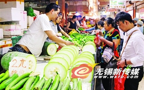 昨天,市民在一家农贸市场选购蔬菜。受梅雨影响,本地蔬 菜价格小幅上扬。 (晚报记者 方正 摄)