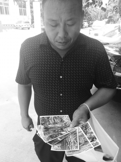邹奇(化名)向记者展示房产材料