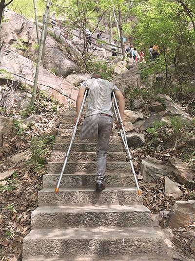 大图:杨太满拄着拐杖登山;