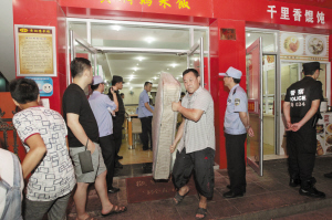工作人员从“黑旅馆”中搬出了床垫等物品。