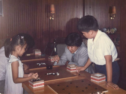 小林觉当年27岁，文静和气。他趁闲与滟儿玩五子连珠。右立者是潋儿。（海上世界比赛休息室／1986.6）