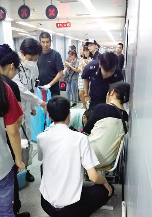 医护人员和地铁工作人员对身体不适的乘客进行检查和安抚。 本报记者 吴迪 摄
