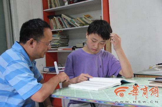 27日上午,14岁的王鑫瑞右和父亲在家查看招生手册,寻找适合报考的学校及专业