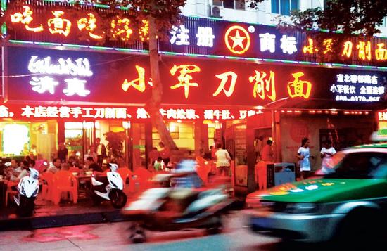 27日晚，小军刀削面店内生意红火