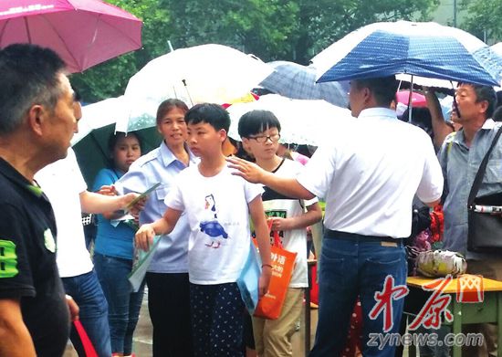 27日下午，在省實驗文博學校內，家長冒雨陪著孩子前來測試。