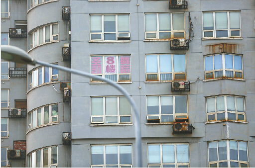 二环东路与华龙路附近的楼上张贴的广告 记者李鹏飞 摄