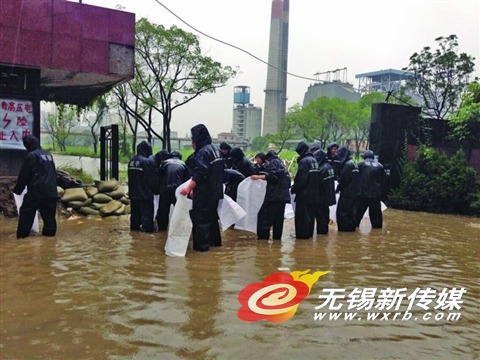 新惠路老橡胶厂被淹,城管队员在用沙袋堵漏。(李忠兰 摄)