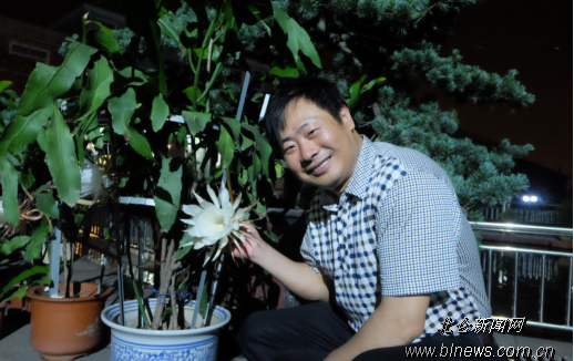 图为总经理成维发在昙花旁。(记者 王珏 摄)