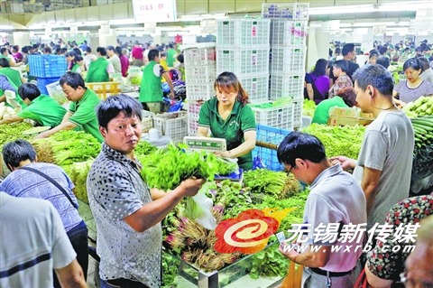 昨天,市民在农贸市场购买叶菜。