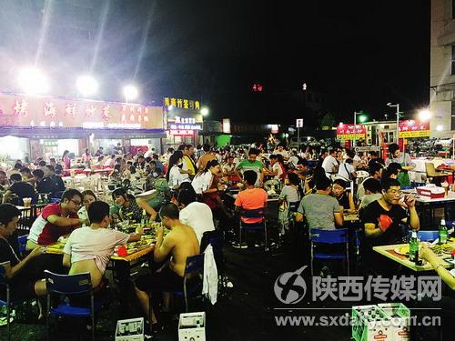 夜幕降临，连片的烧烤摊生意火爆，人声鼎沸。